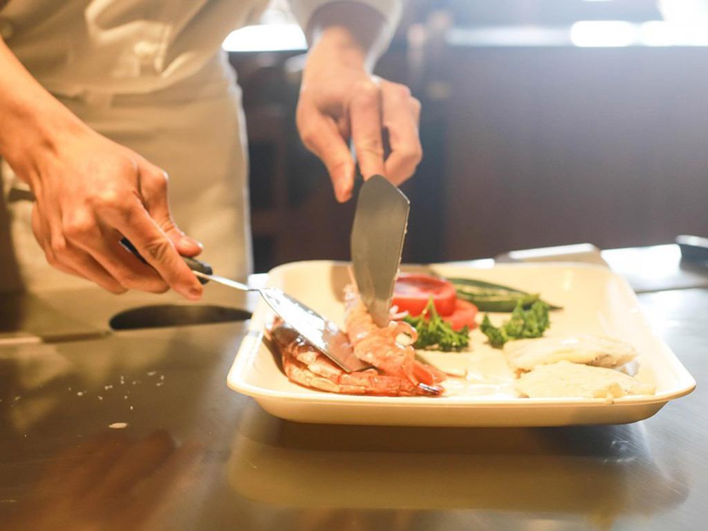 Fisch, Gemüse und andere Lebensmittel werden ordentlich auf einem Teller plaziert.