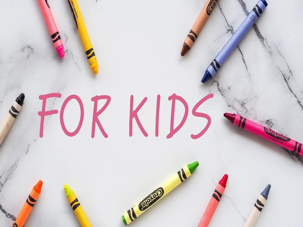 Bunte Stifte liegen neben einem weißen Feld mit der Aufschrift „for kids“