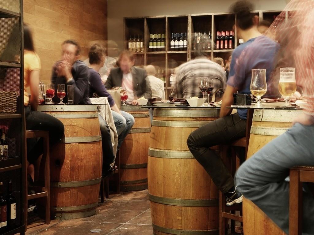 Mehrere Menschen sitzen zusammen bei Tapas, unterhalten sich und trinken Getränke